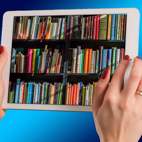 Um tablet sendo usado para leitura, representando a busca por aparelhos de baixo custo para mídia e uso familiar.