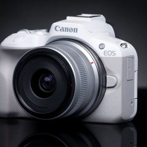 Canon EOS R50 mirrorless camera on a dark product-photography background.
