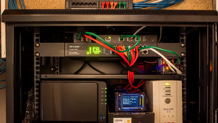 Home network cabinet with a switch, NAS, small router and UPS battery backup.