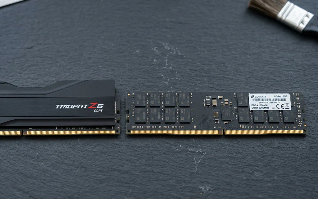 Módulos de memoria RAM DDR5 y DDR4 uno al lado del otro sobre una mesa de pruebas.