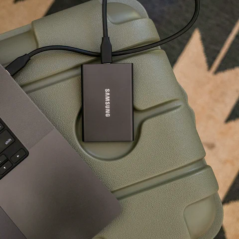 SSD portátil externo conectado a um notebook para backup e planejamento de armazenamento.